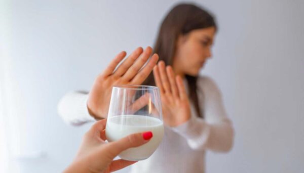 Intolerância à Lactose (IL) Imagem de Mulher rejeitando com copo de leite devido à intolerância à lactose